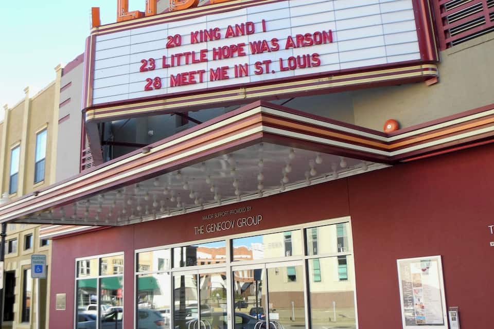 A theater with a marquee displaying movie titles.