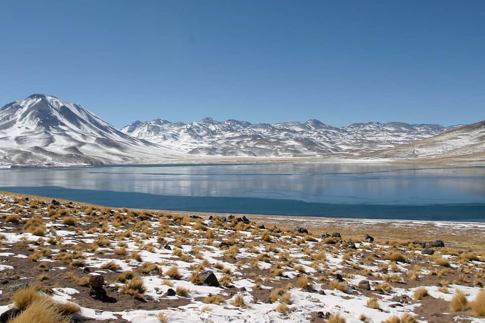 Ein Gebirge, ein großer See und vereinzelte Vegetation.