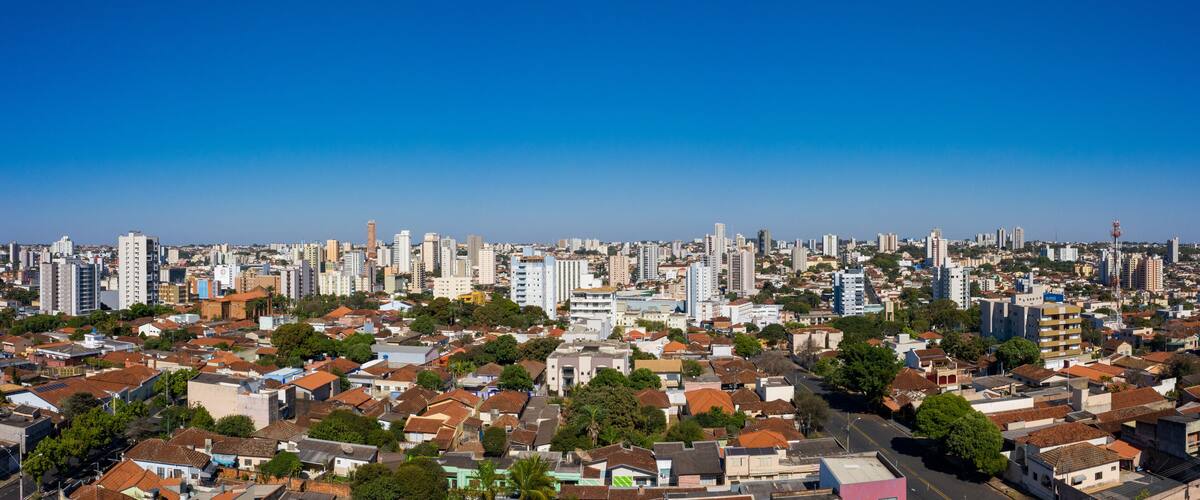 A cityscape with dense residential buildings, a clear blue sky, and a mix of high-rise and low-rise structures.