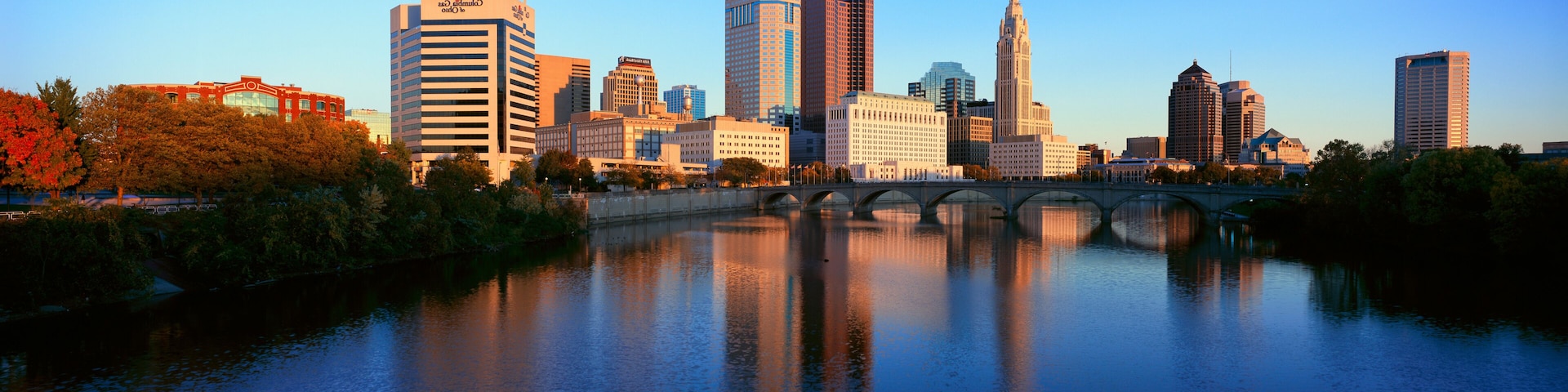 A city skyline with a river and a bridge.