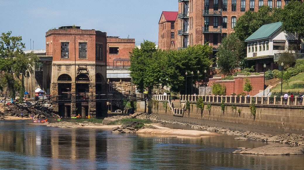 Chattahoochee River shoreline as it passes through Columbus, Georgia on a sunny weekend day with rafters and kayakers preparing to enjoy a day of drifting on the river.