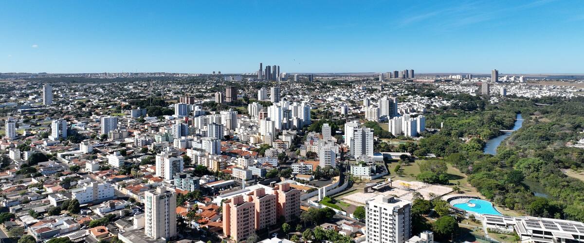 A cityscape with dense urban buildings, a river, and a large swimming pool.