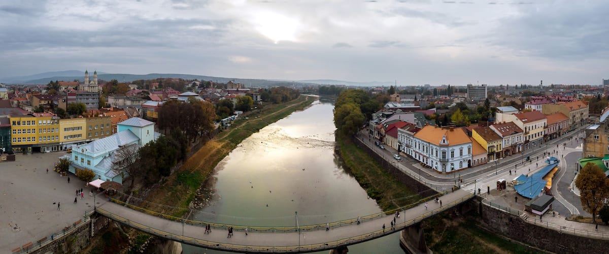A river flowing through a city with historic buildings and a bridge.