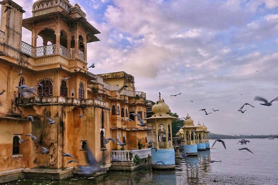 Un bâtiment historique à l’architecture riche et élaborée, situé au bord d’une étendue d’eau paisible.