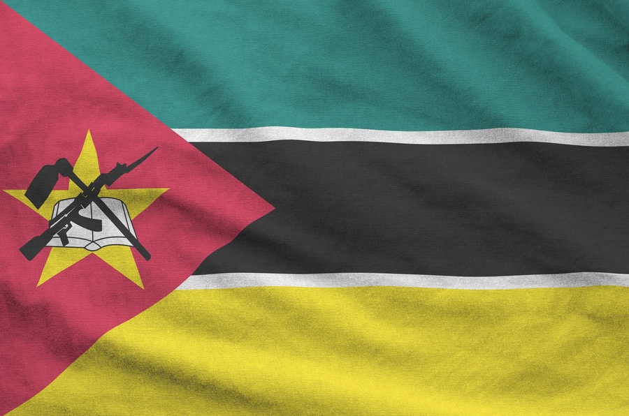 Mozambique flag depicted on folded wavy fabric of old cloth close up