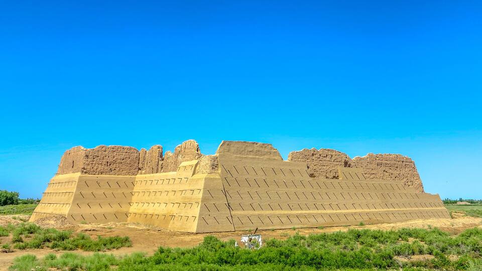 A large ancient pyramid-like structure in a desert landscape.