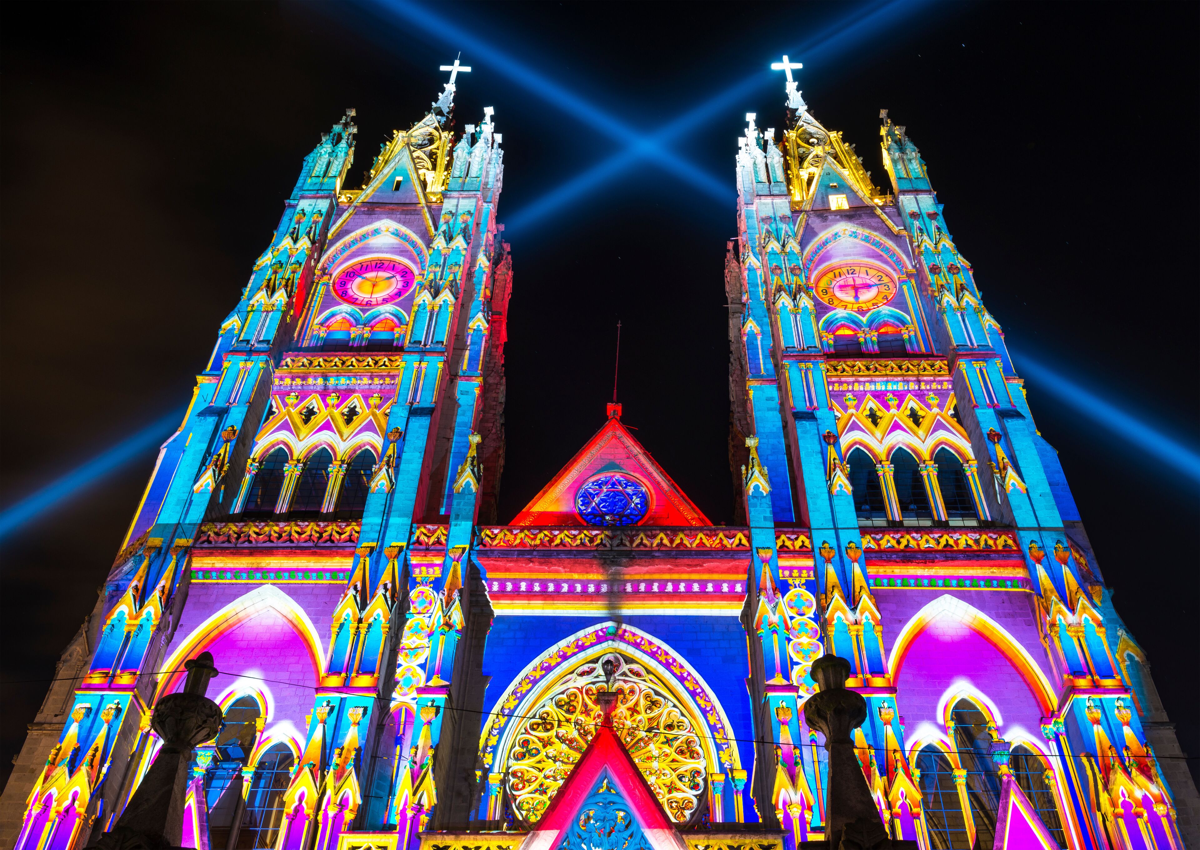 The neo - gothic style Basilica of the National Vow (Basilica del Voto Nacional) illuminated with colorful lights during the Quito light festival.