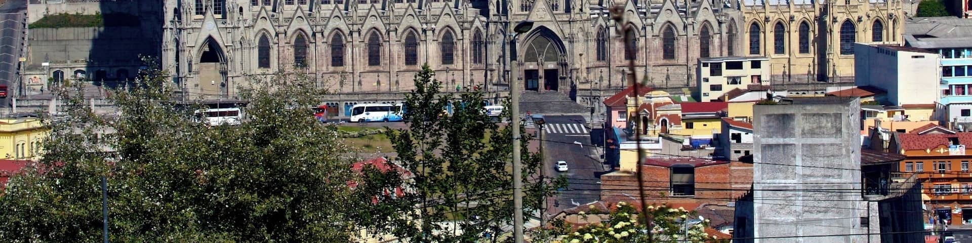 A cathedral with Gothic architecture amidst a densely packed urban area.
