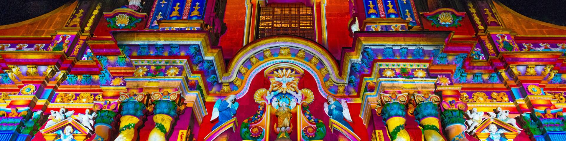 The facade of the Compania de Jesus church illuminated with colorful lights during the light festival, Quito, Ecuador.