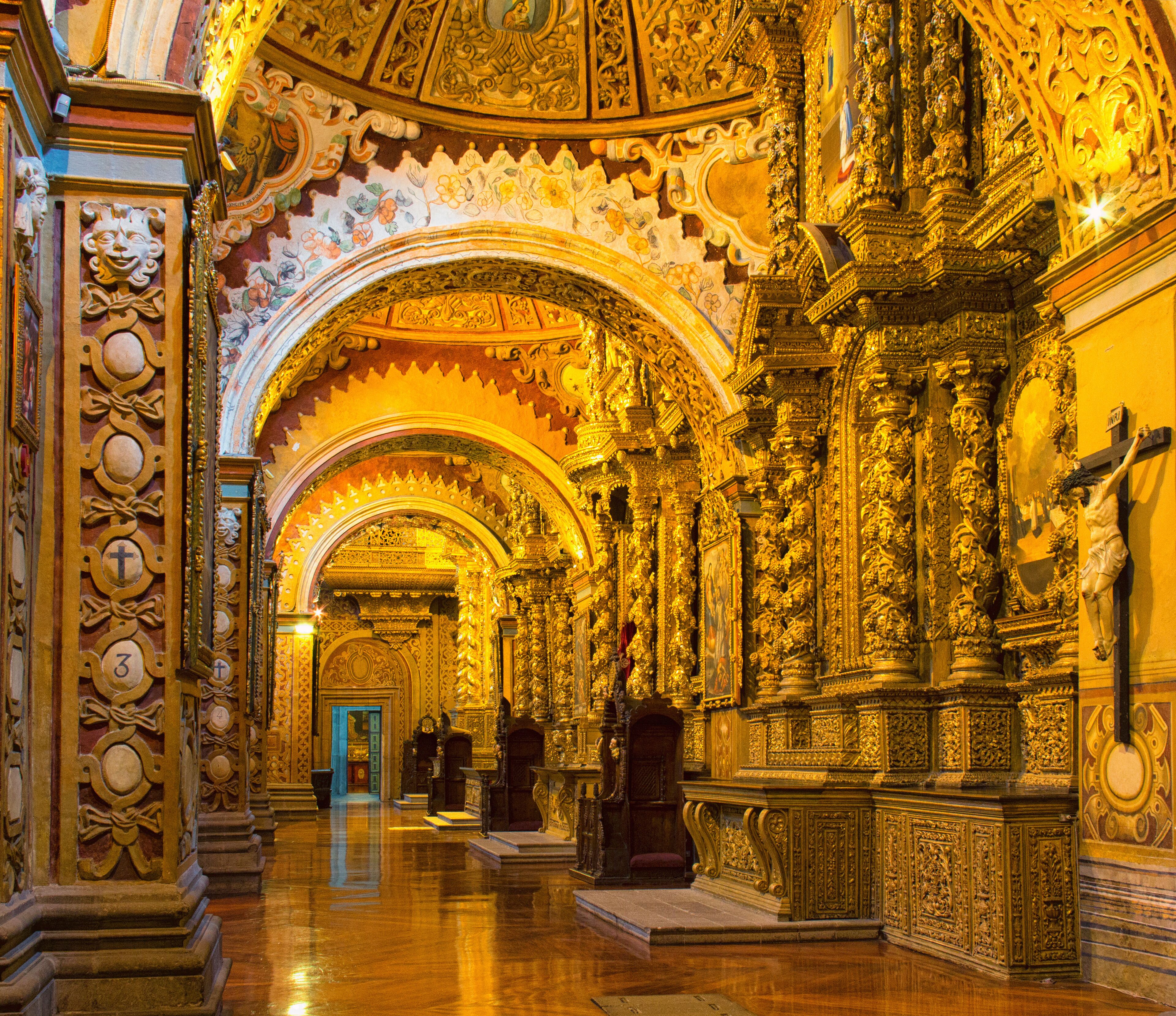 Un interior ornamentado con arcos dorados y detallados grabados.