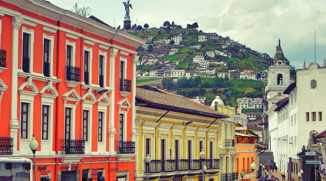 Typical colourful Latin American street in the old quarter of Quito with the Virgin Mary statue in the background. The view from the top of the hill gives a view of the massive expanse of the city of Quito.