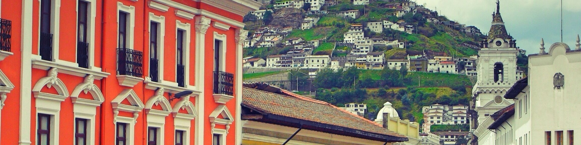 Typical colourful Latin American street in the old quarter of Quito with the Virgin Mary statue in the background. The view from the top of the hill gives a view of the massive expanse of the city of Quito.