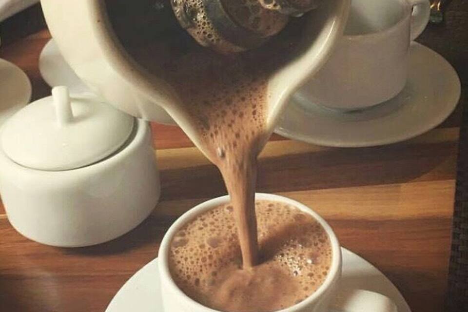 A coffee machine pouring espresso into a cup.