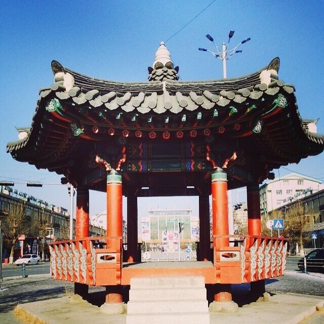 A traditional Korean pavilion with ornate roof tiles and red pillars.