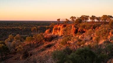 A rugged landscape with rocky outcrops and sparse vegetation, likely a desert or semi-arid region.