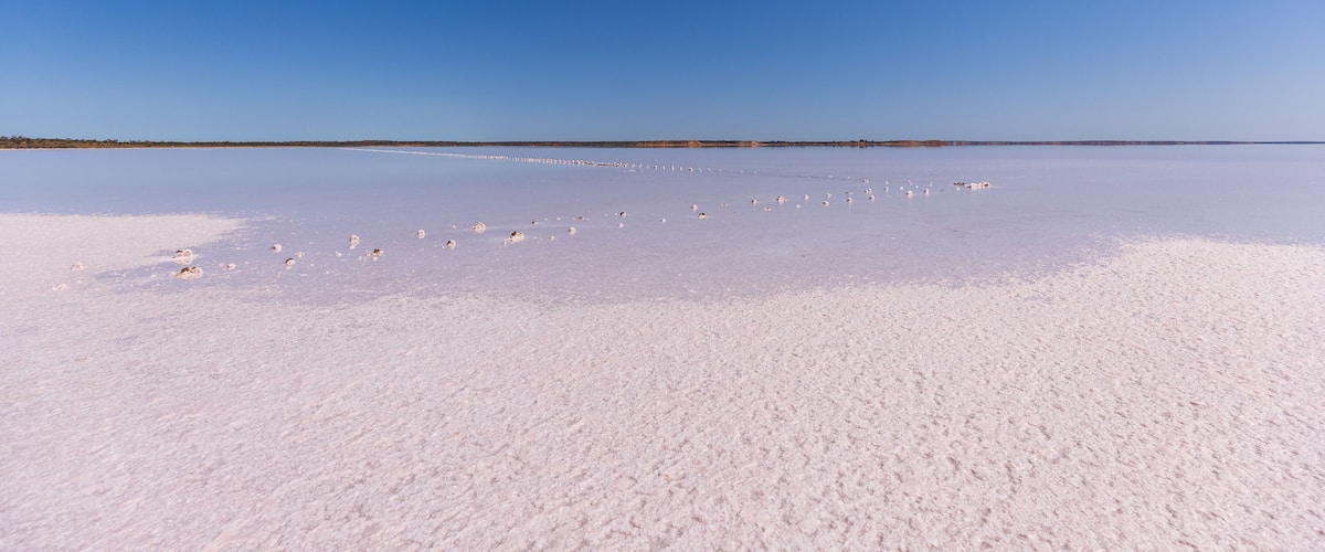 A vast salt flat under a clear blue sky.
