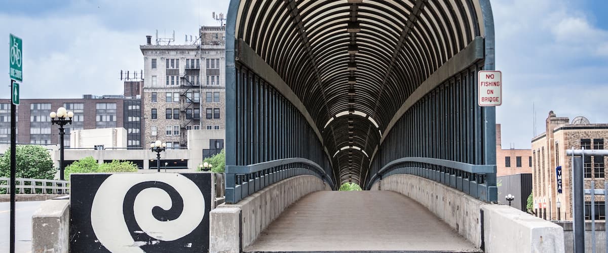 The 4th Street Bridge covered walkway in downtown Waterloo, Iowa on a beautiful summer day with clouds in the sky.