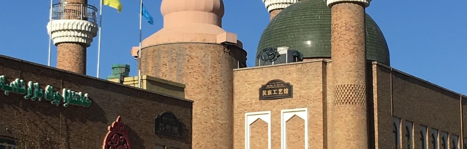 In the courtyard outside the Grand Bazaar in Urumqi. The Mosque in the background.
