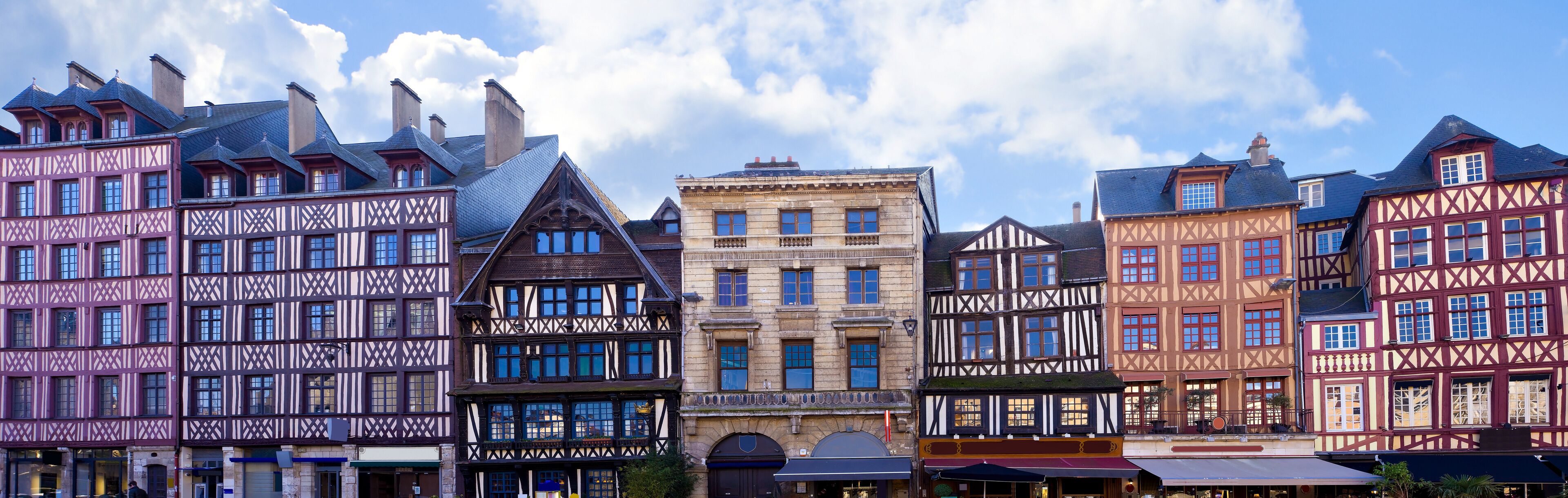 A row of half-timbered buildings with a mix of colors and architectural styles.