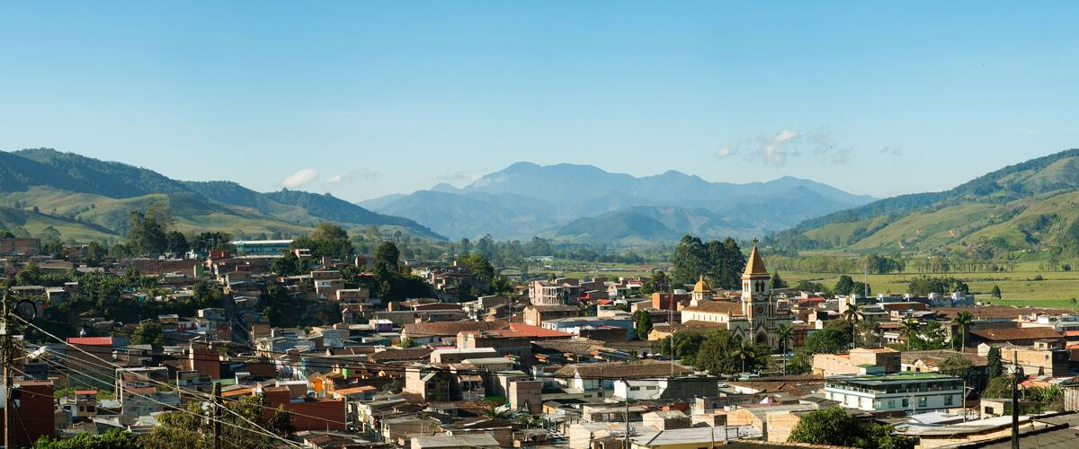 A town nestled in a valley with mountains in the background.