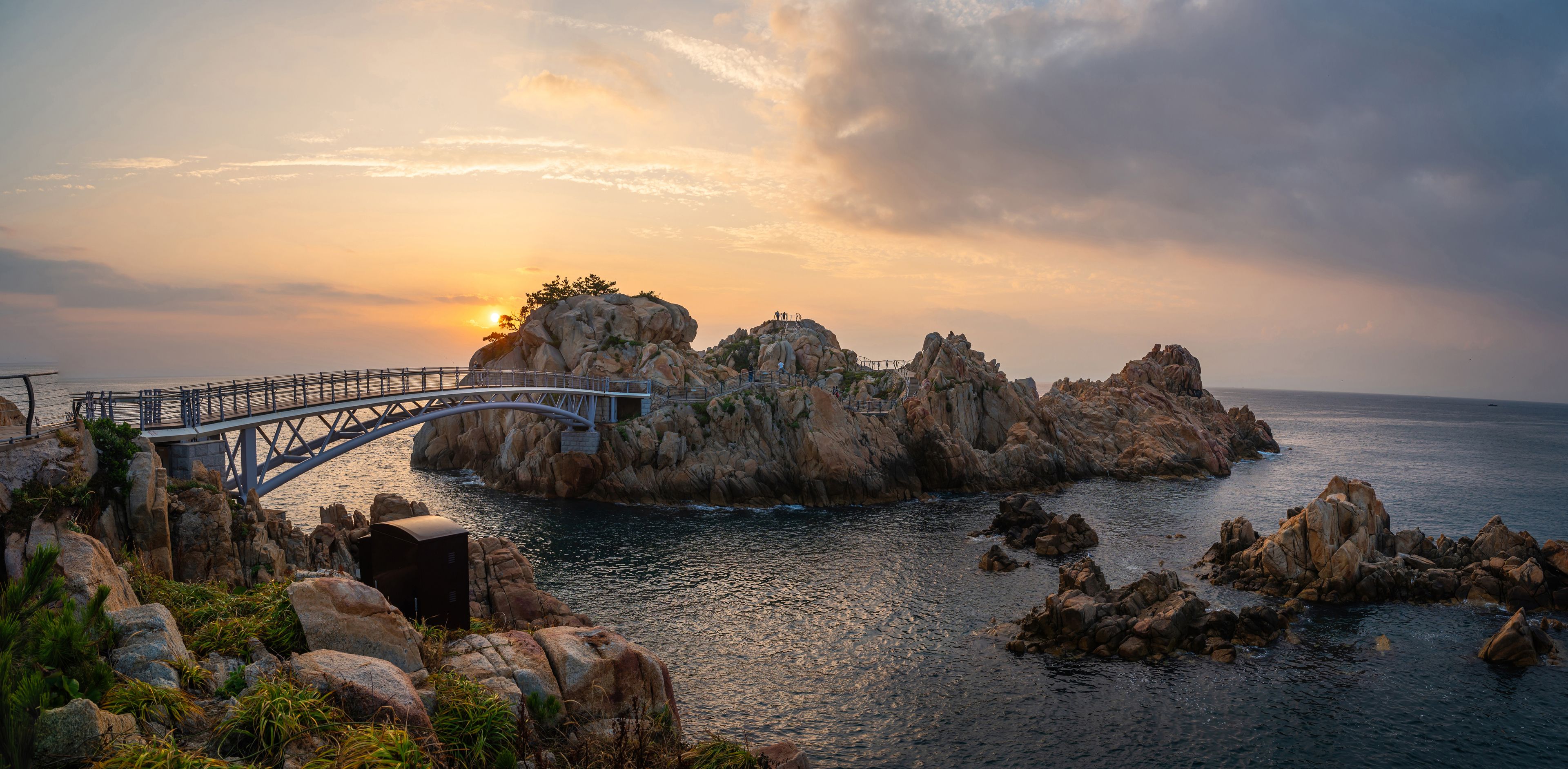 Summer and morning view of Daewangam Rock with arch iron bridge on the sea against horizon at Daewangam Park, Dong-gu, Ulsan, South Korea
