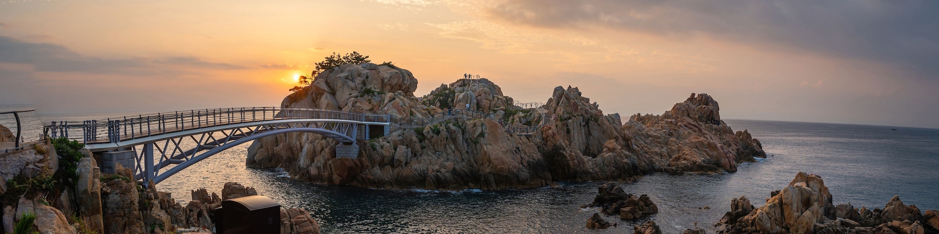 Summer and morning view of Daewangam Rock with arch iron bridge on the sea against horizon at Daewangam Park, Dong-gu, Ulsan, South Korea