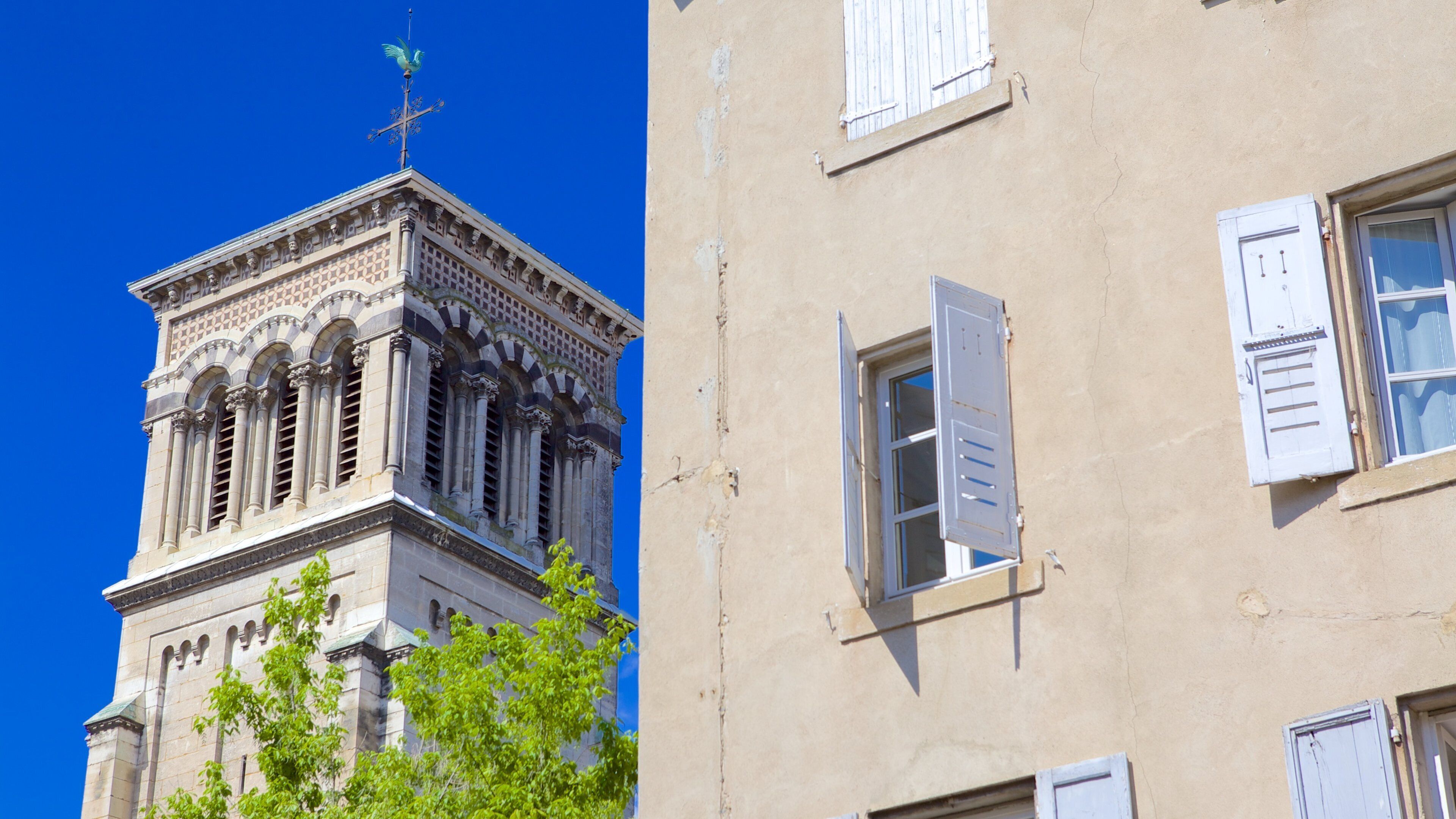 A historic building with ornate architecture and a weather vane on top.