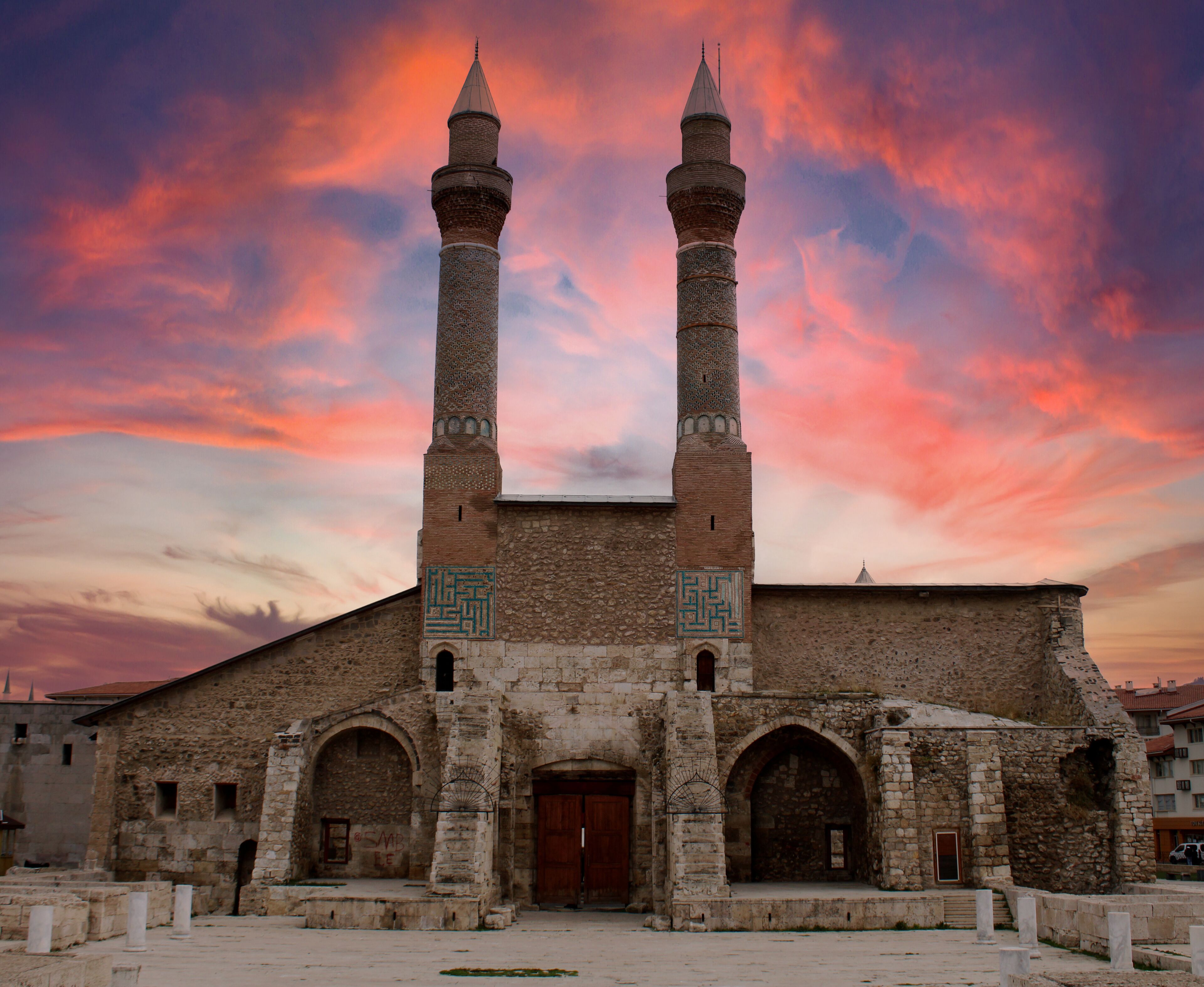 A historic building with two tall minarets and a large arched entrance.