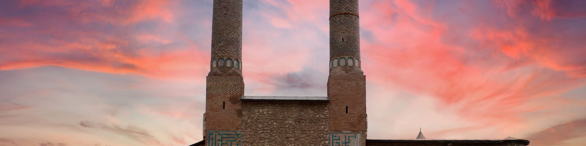 A historic building with two tall minarets and a large arched entrance.