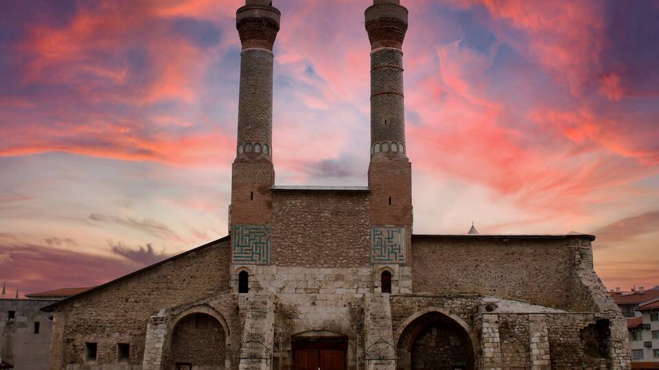 A historic building with two tall minarets and a large arched entrance.