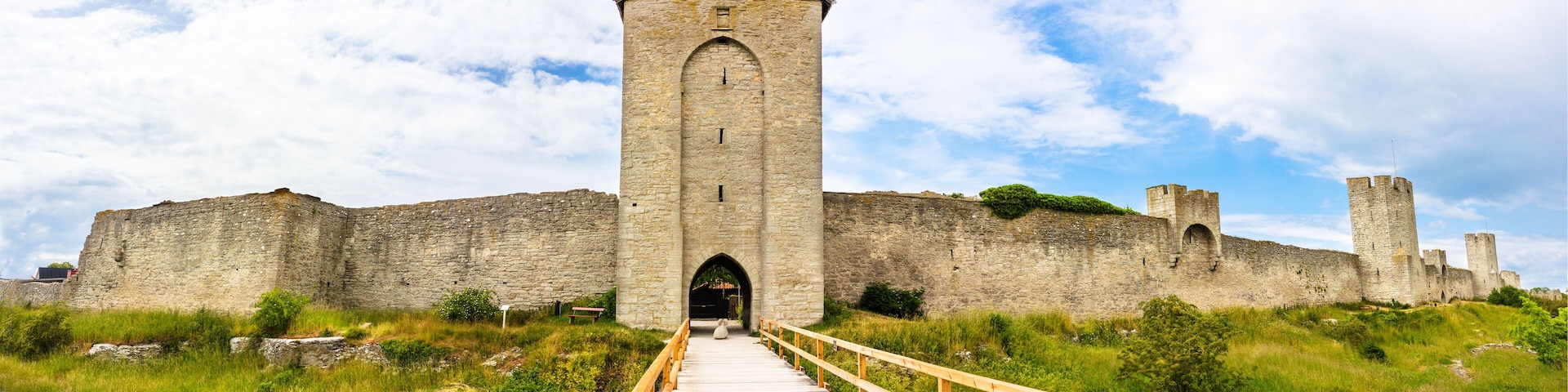 A medieval castle with a wooden walkway leading to the entrance.