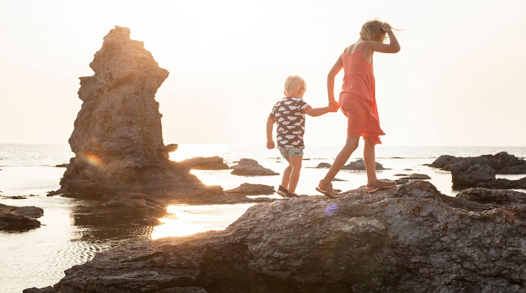 Sweden, Gotland, Faro, Gamle hamn, Girl (8-9) walking with brother (2-3) on coastal rocks