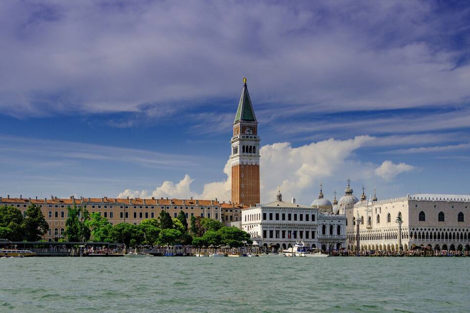 A historic waterfront cityscape with prominent architecture, including a tall tower and domed buildings.