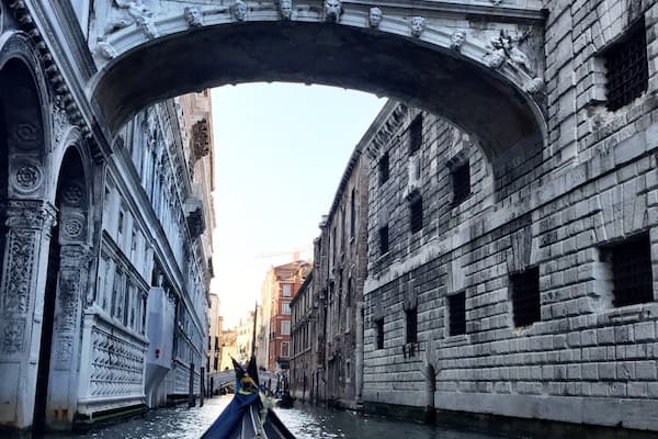 Gondola ride under The Bridge of Sighs in Venice. This bridge connects the prison to the interrogation rooms in the Doge's Palace. Through the stone barred windows of the bridge, convicts saw their last views of Venice before they were imprisoned.