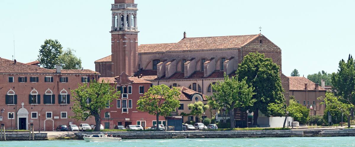 A historic building with a prominent tower and a waterfront.