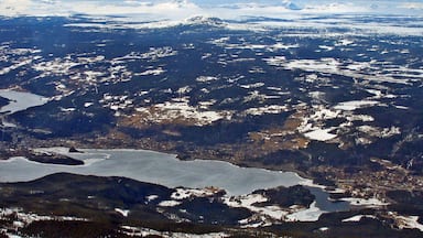 A mountainous landscape with snow-covered peaks and a large body of water.