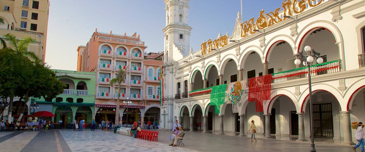 A plaza with a clock tower, a building with 'Mexico' written on it, and several restaurants.
