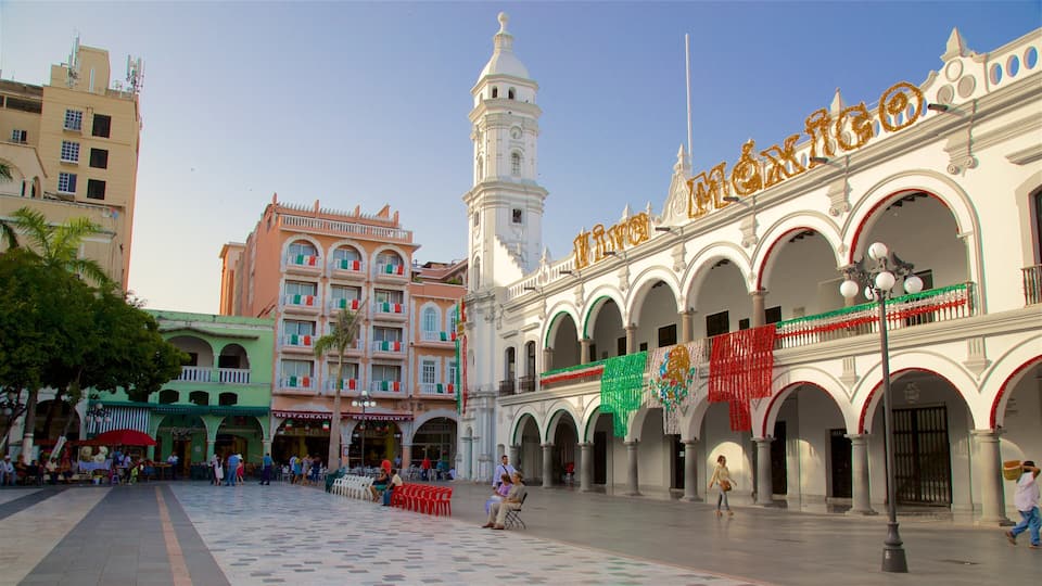 A plaza with a clock tower, a building with 'Mexico' written on it, and several restaurants.