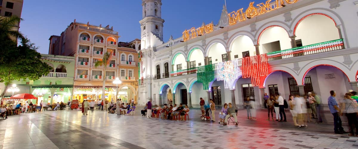 A historic plaza with a prominent clock tower and the 'Viva México' sign.