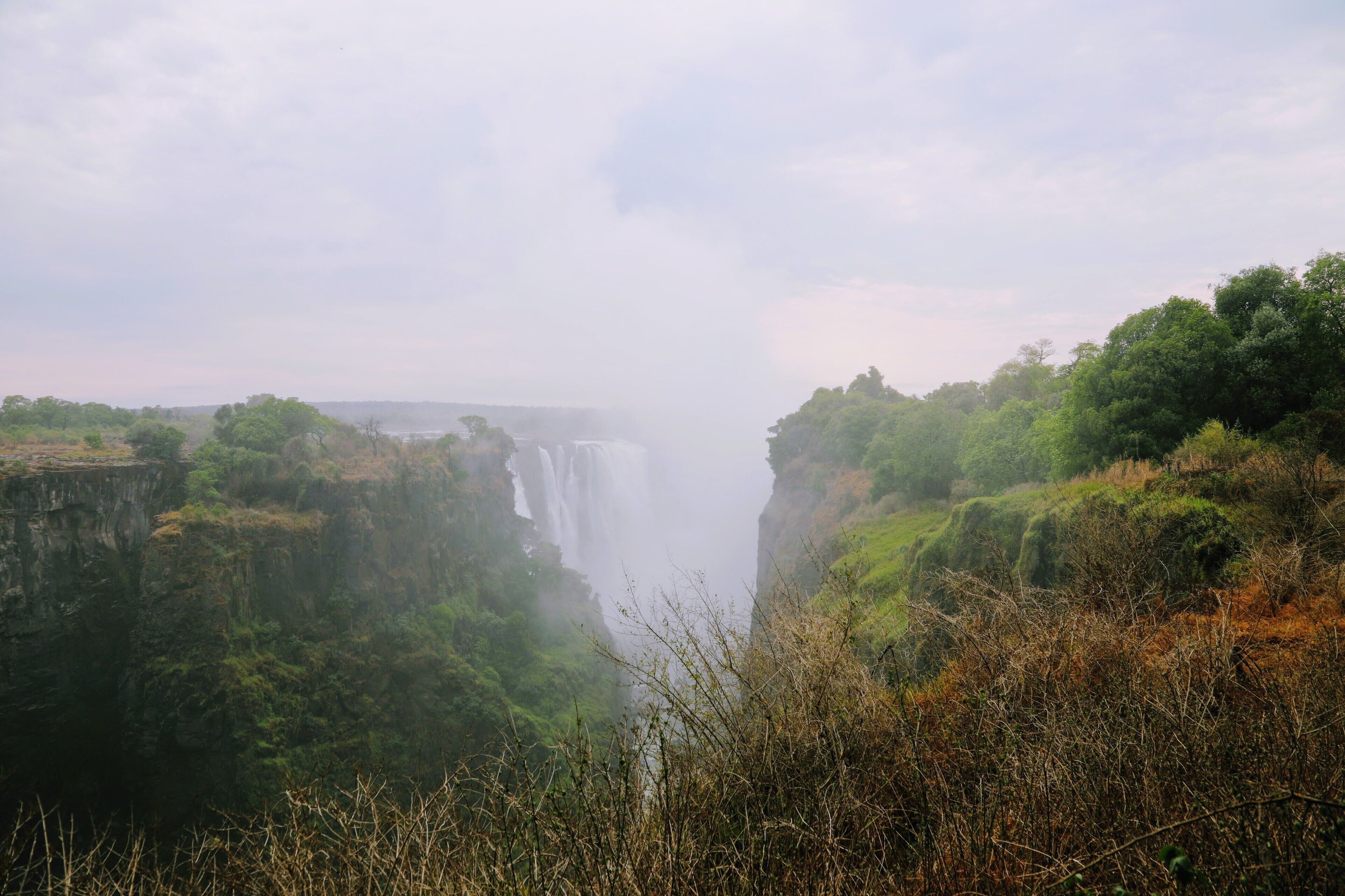 This is a picture of Victoria falls in the low season from the Zimbabwe side, See how lush and green everything is, what is amazing is just a few yards away its all brown and looks like Colorado's plains in the winter. Its only when it gets near the year around spray that it becomes suddenly jungle like.  I blogged about my few days there at http://circlingthebucketlist.com/index.php/2018/11/23/a-day-at-victoria-falls/