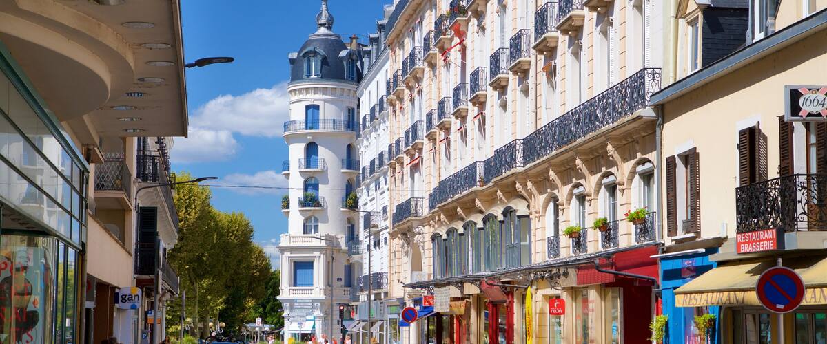 A street with historic buildings, a tower, and storefronts.