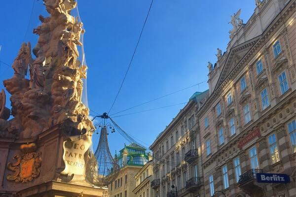Ein historischer Platz mit aufwendigen Statuen, einem Riesenrad und klassischer Architektur.