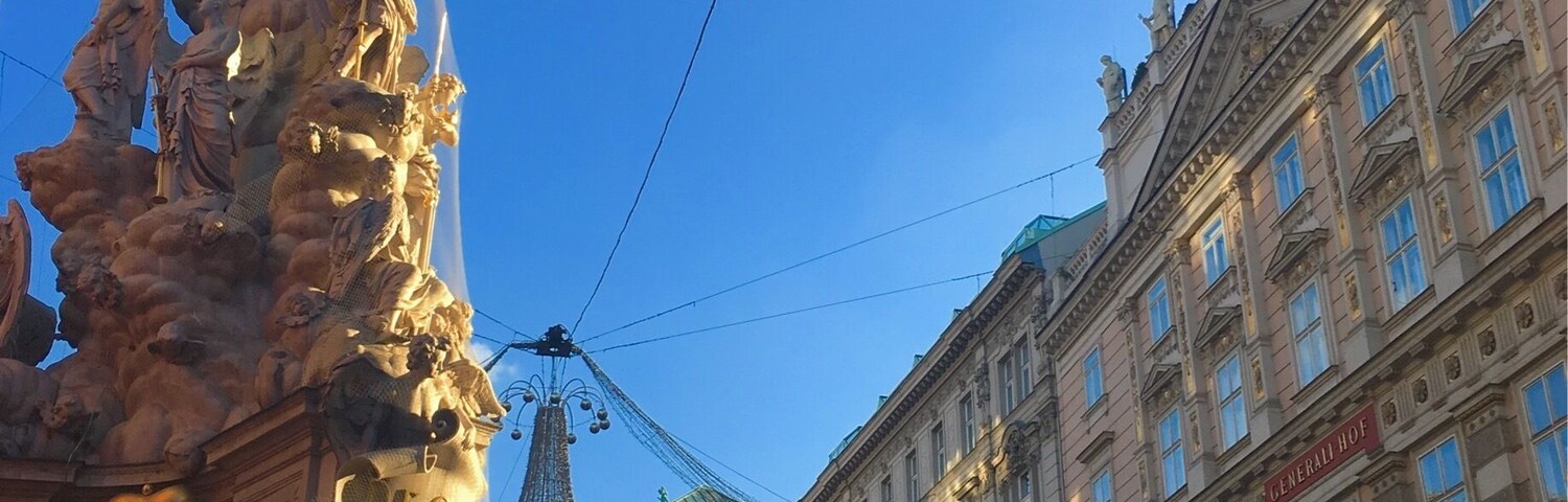 Uma praça histórica com estátuas elaboradas, uma roda-gigante e arquitetura clássica.