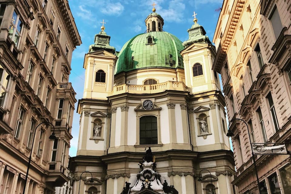 Uma igreja histórica com cúpula verde e arquitetura elaborada.
