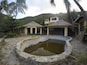 Another high end-looking place destroyed. It has only 5 rooms or so. A tennis court. And a sailboat rolled up against the outdoor bar. You can access by dinghy.
This is the pool, outdoor kitchen (?), indoor bar on the right, and penthouse on top.