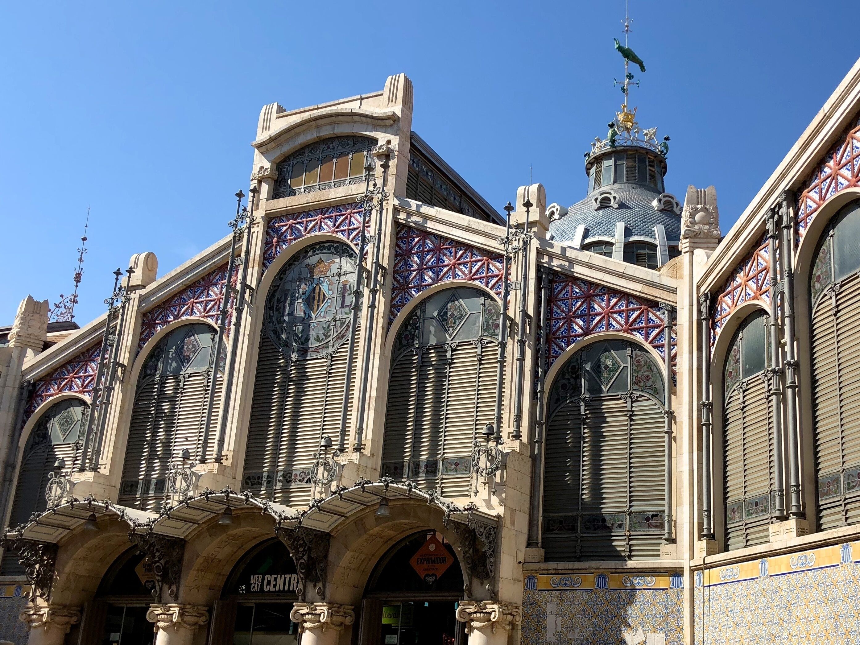 Un edificio histórico con arquitectura ornamentada, amplias ventanas en arco y detalles intrincados en cerámica.