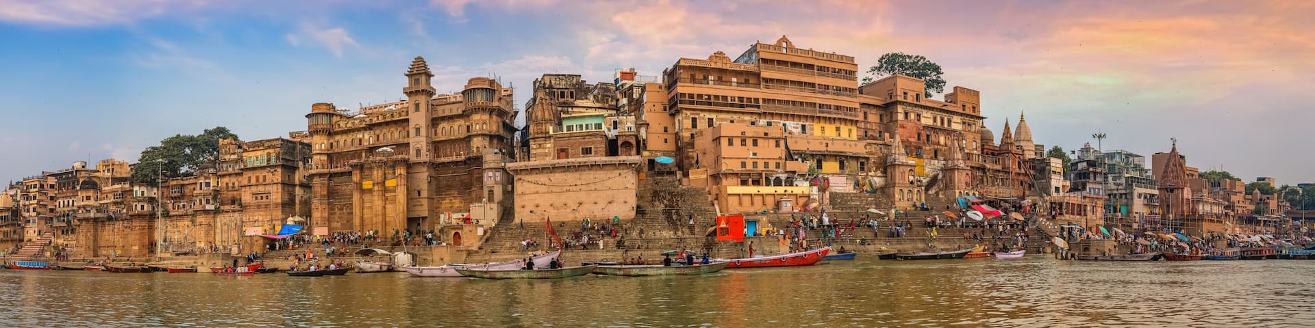 Varanasi India ancient city architecture panoramic view at sunset as seen from a boat on river Ganges.