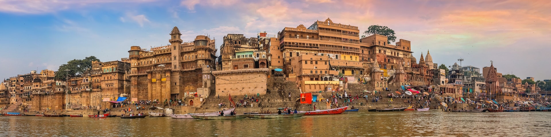 Varanasi India ancient city architecture panoramic view at sunset as seen from a boat on river Ganges.