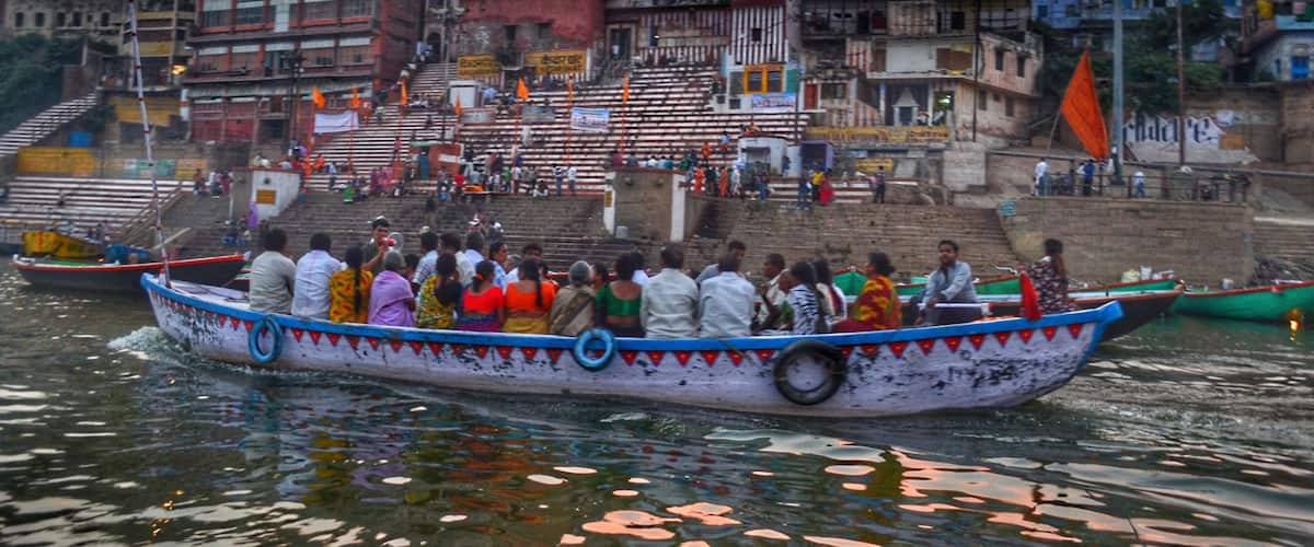 Ganga Aarti performed at dusk on the banks of the Ganges River in one of the oldest living cities in the world. Boats are filled to the brim with people wanting to watch the performance.