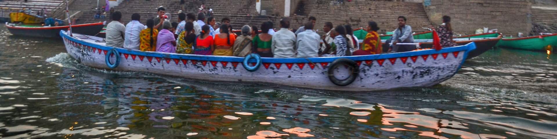 Ganga Aarti performed at dusk on the banks of the Ganges River in one of the oldest living cities in the world. Boats are filled to the brim with people wanting to watch the performance.